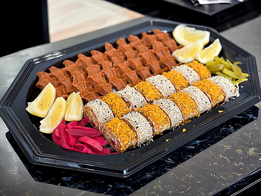 Verschiedene Çiğköfte-Spezialitäten von Finest Çiğköfte auf Schiefertellern angerichtet